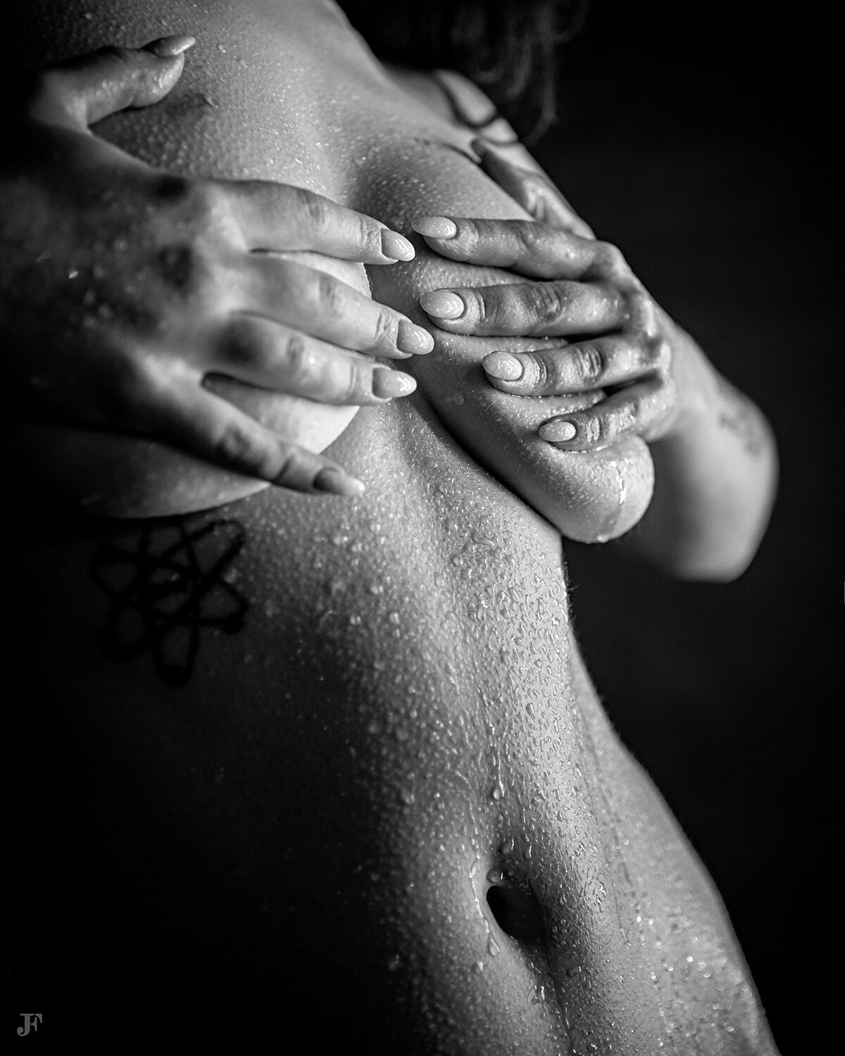 In this image we can see a woman. There is a tattoo on her body.