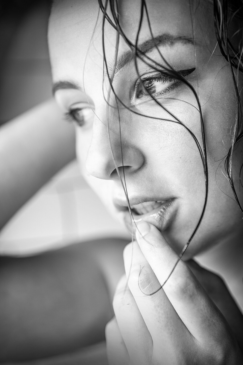 The image shows a black and white portrait of a woman with her hand on her chin, her face illuminated by the light of the setting sun.